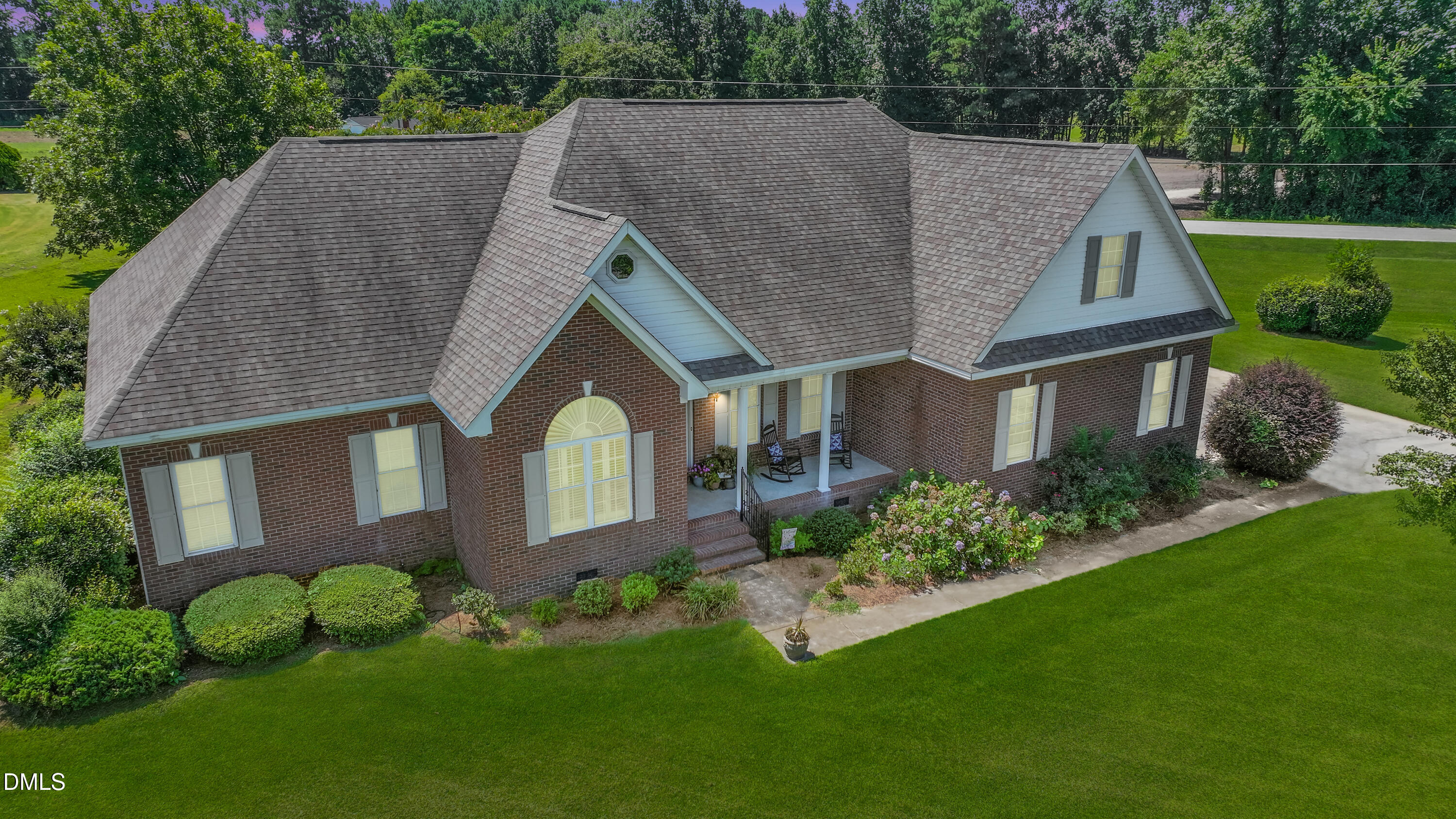 a aerial view of a house next to a big yard and large trees