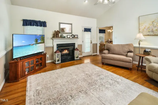 a living room with furniture a flat screen tv and a fireplace