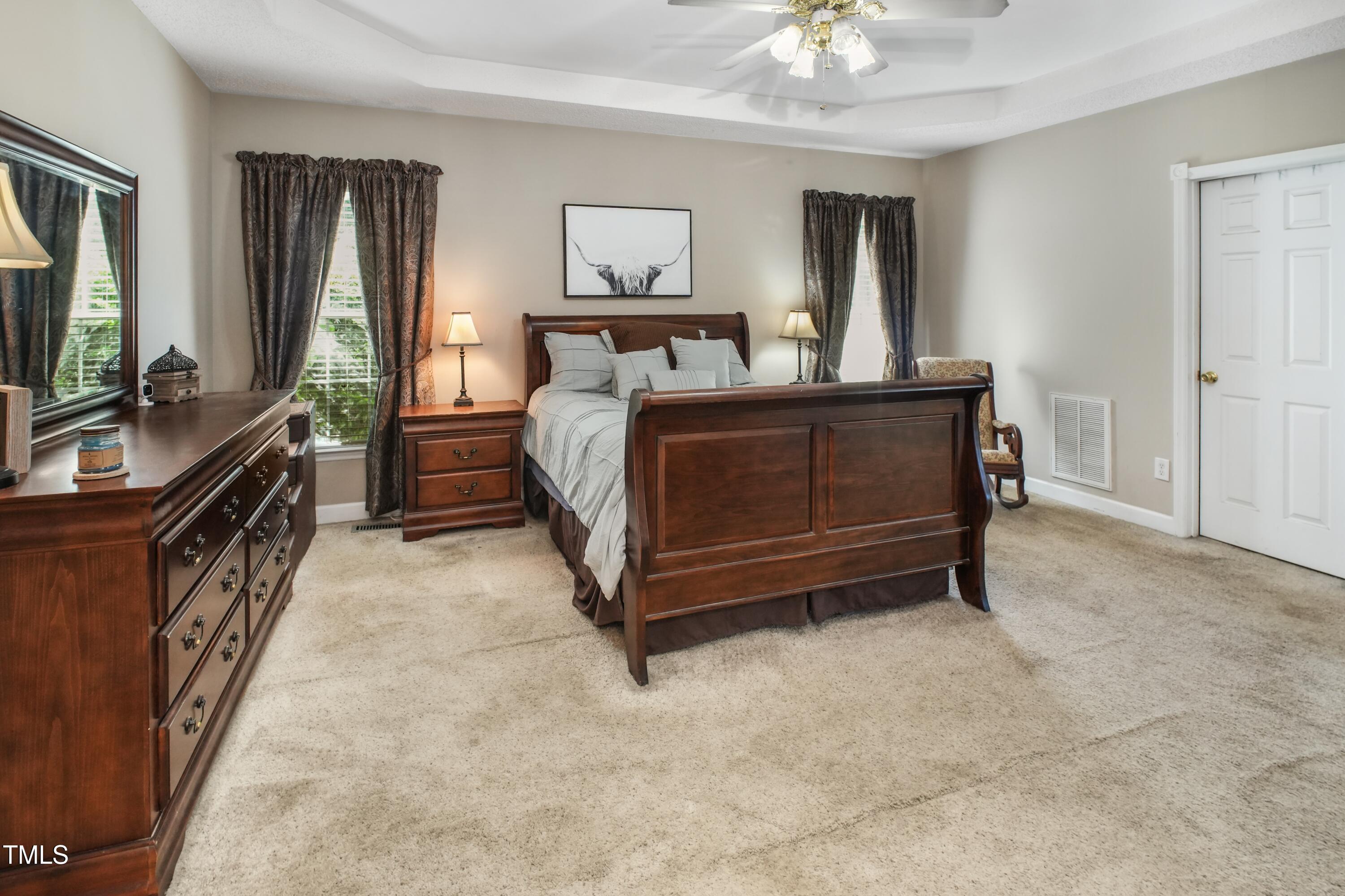 115 Hunters Walk Lane Clinton, NC 28328 - Photo 24 of 39 a bedroom with a bed and a chandelier