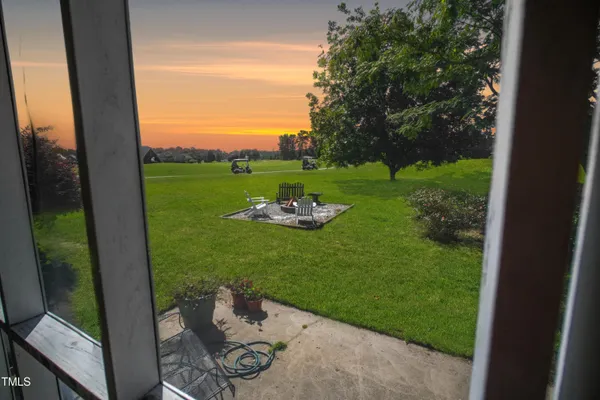 a backyard of a house with fountain table and chairs