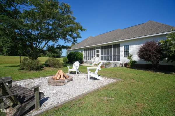 a view of a chair and table in backyard of the house