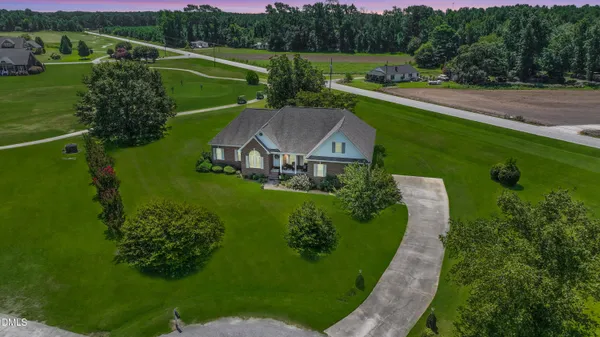 an aerial view of a house with outdoor space and a garden