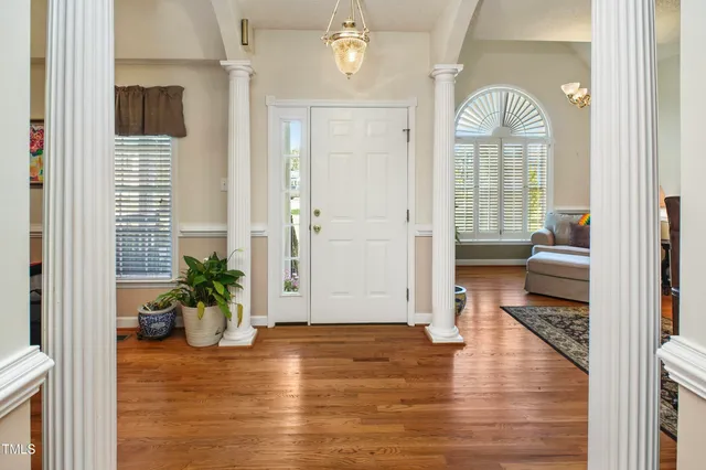 a view of a hallway with wooden floor and a living room