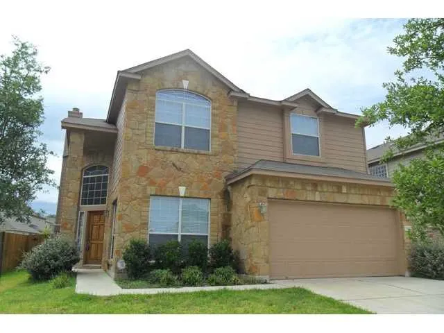 a front view of a house with a yard and trees
