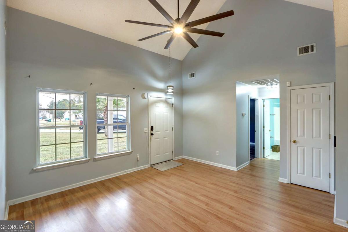 221 Oakwood Court Rincon, GA 31326 - Photo 7 of 35 a view of an empty room with window and wooden floor