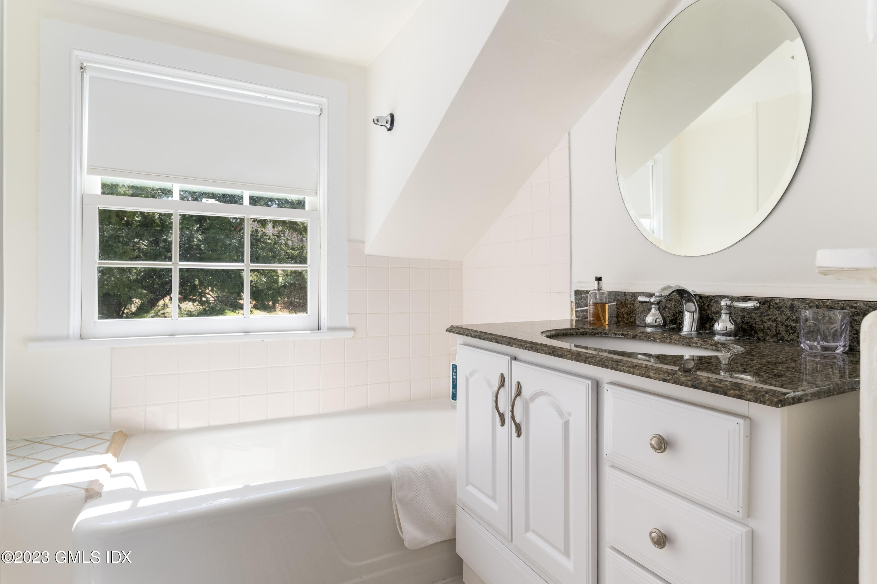 470 June Road Stamford, CT 06903 - Photo 25 of 26 a bathroom with a granite countertop sink a mirror a vanity and a bathtub