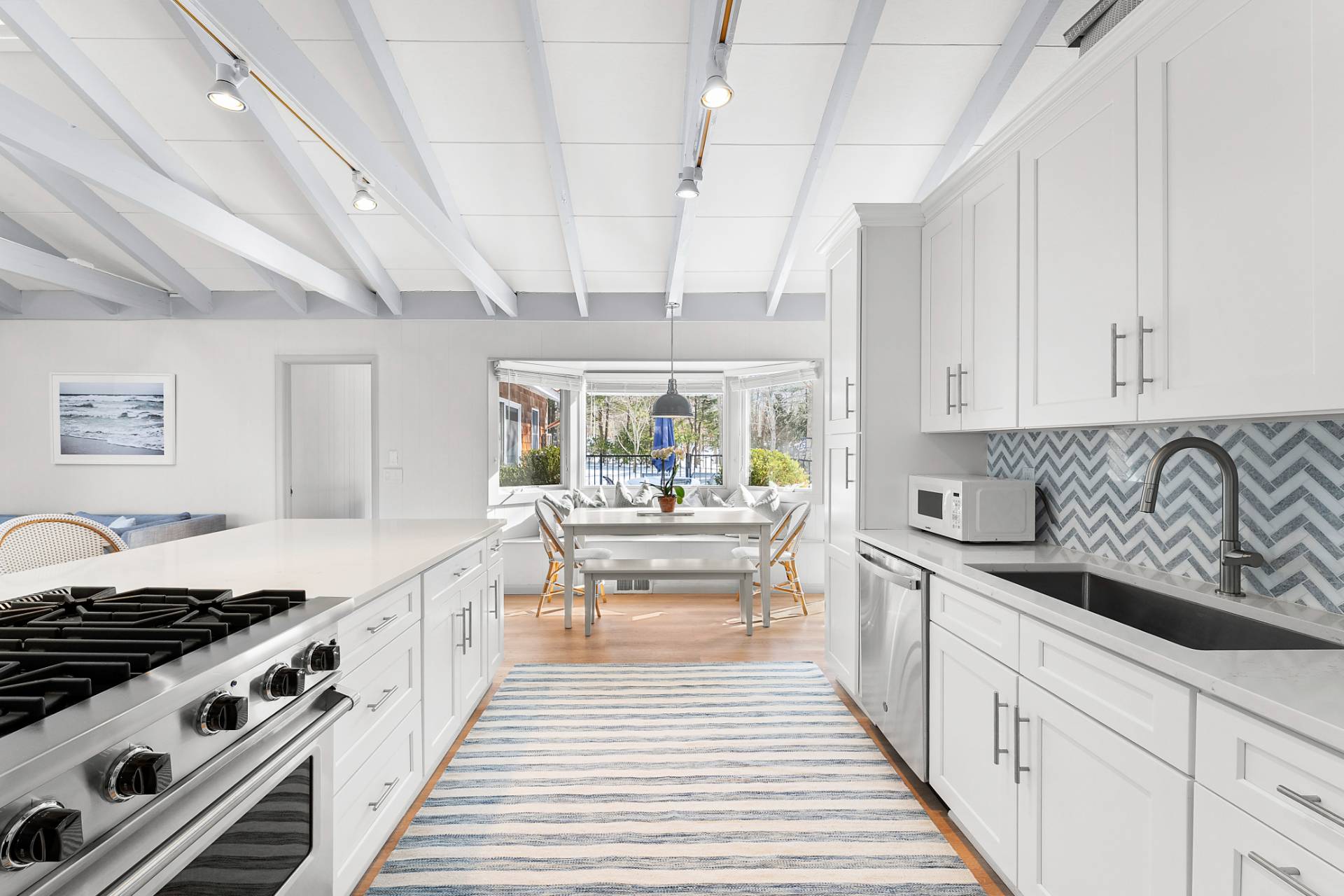 a kitchen with stainless steel appliances a white stove top oven and white cabinets