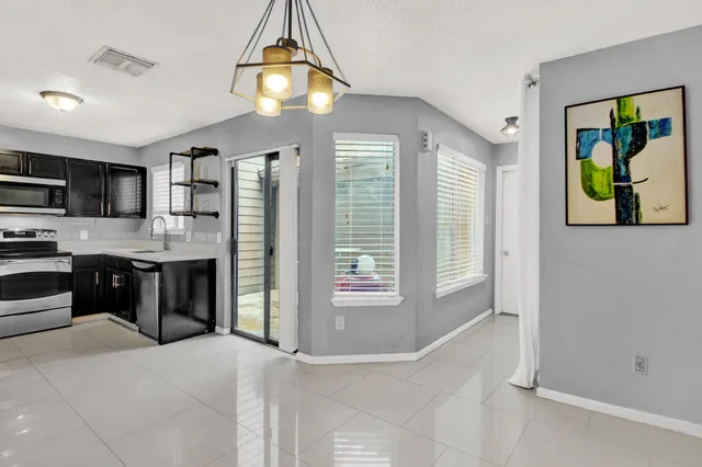 a open kitchen with kitchen island granite countertop a refrigerator stove top oven a sink and dishwasher