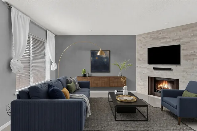 a living room with furniture a flat screen tv and a fireplace