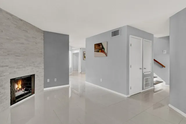 an empty room with a fireplace and entryway