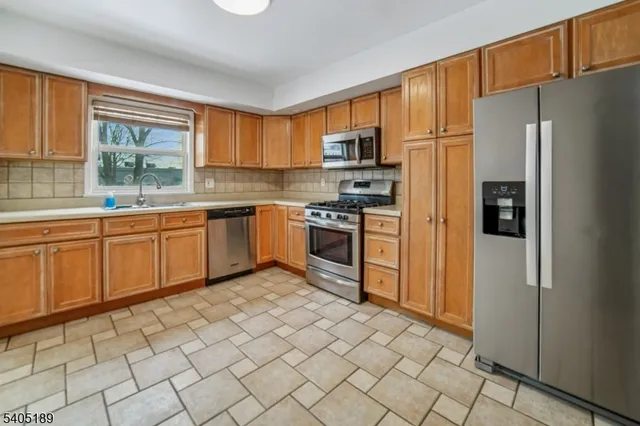 a kitchen with stainless steel appliances granite countertop a refrigerator and a sink