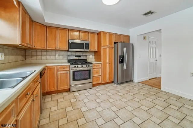 a kitchen with stainless steel appliances granite countertop a refrigerator stove and sink