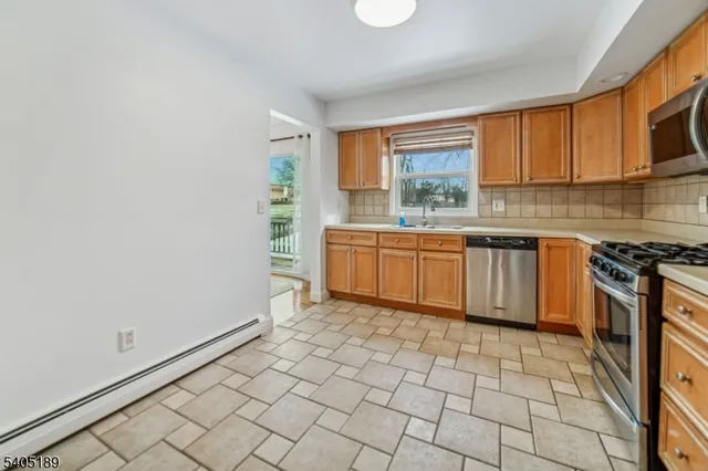 a kitchen with stainless steel appliances a sink stove and cabinets