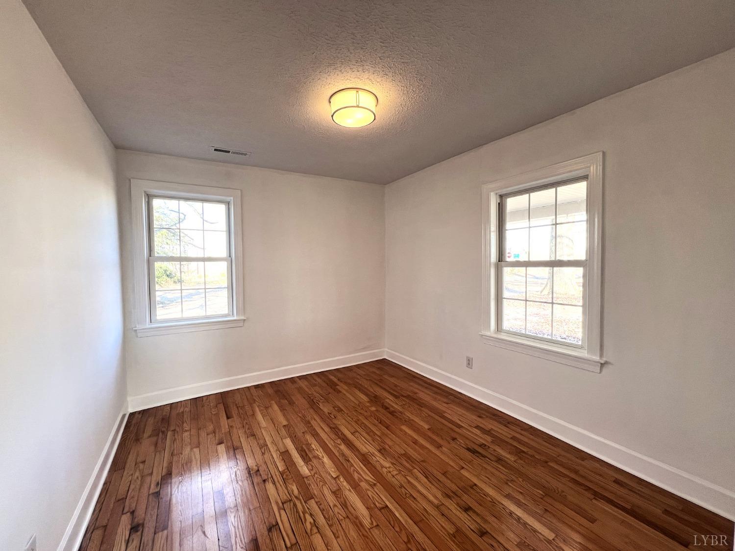 5235 Wards Fork Mill Road Cullen, VA 23934 - Photo 17 of 42 an empty room with windows and wooden floor