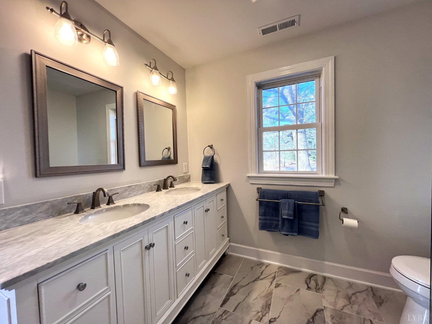 5235 Wards Fork Mill Road Cullen, VA 23934 - Photo 23 of 42 a spacious bathroom with a double vanity sink a mirror and a toilet