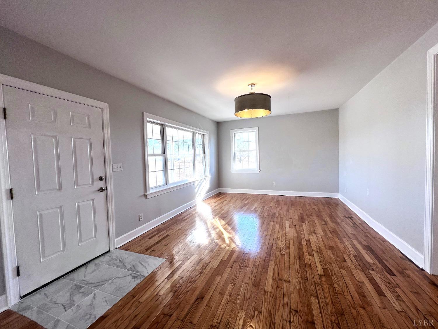 5235 Wards Fork Mill Road Cullen, VA 23934 - Photo 9 of 42 an empty room with wooden floor and windows