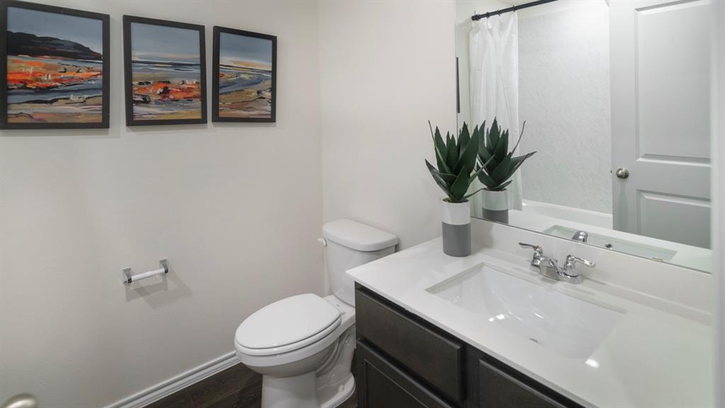 3100 Charleston Drive Ennis, TX 75119 - Photo 2 of 23 Bathroom featuring a white vanity with an integrated sink, dark wood-finish cabinetry, a chrome faucet, and a large mirror
