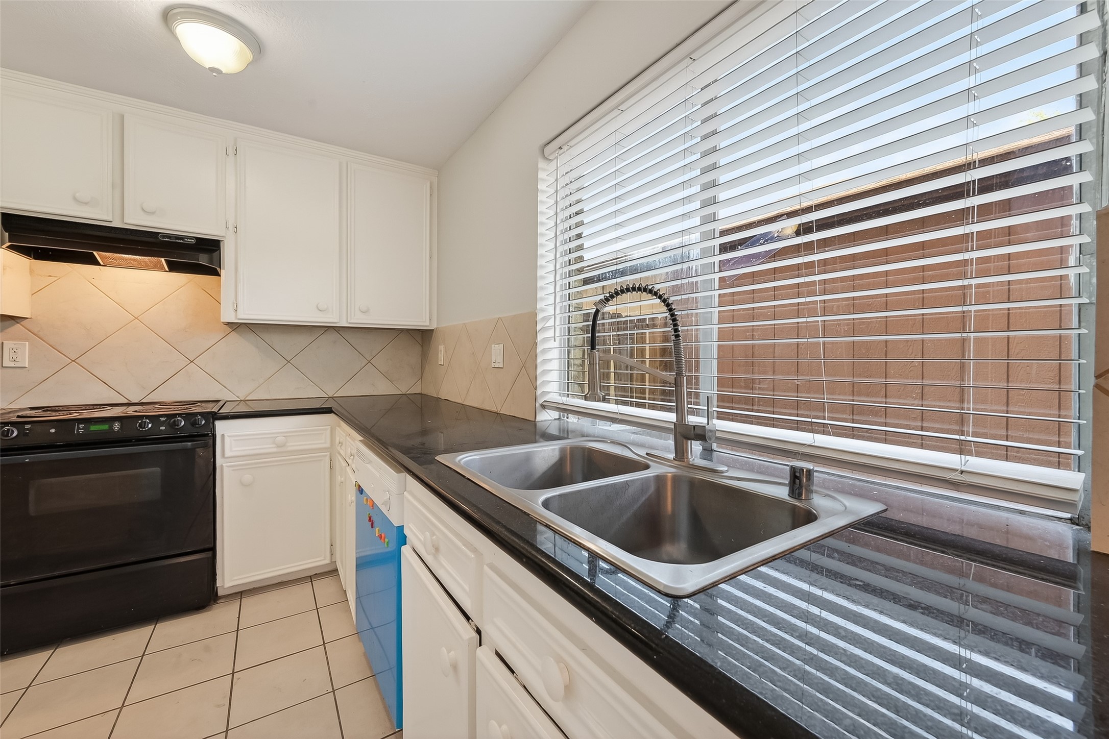 8646 Maplecrest Drive Houston, TX 77099 - Photo 15 of 36 a kitchen with granite countertop a sink stove and cabinets