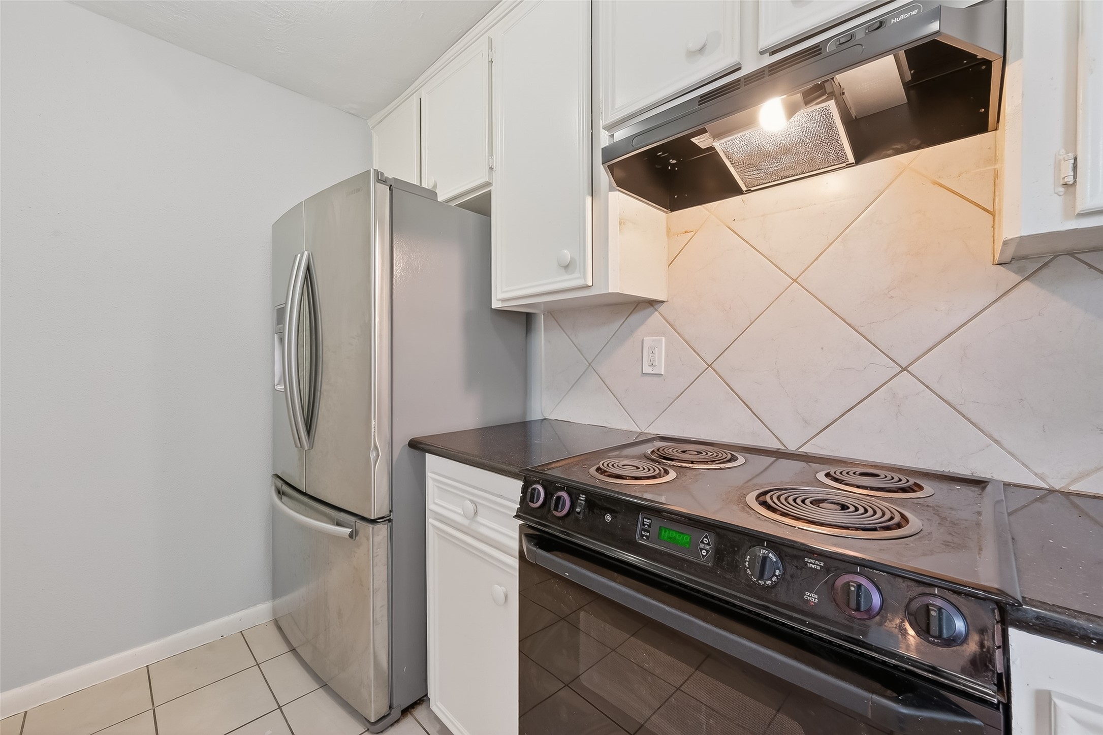 8646 Maplecrest Drive Houston, TX 77099 - Photo 17 of 36 a kitchen with a stove and a refrigerator