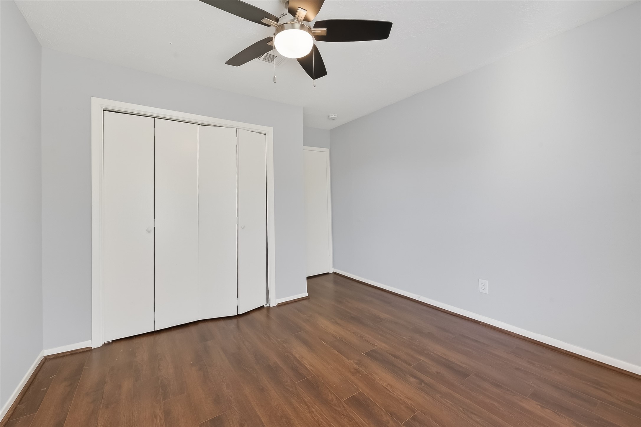 8646 Maplecrest Drive Houston, TX 77099 - Photo 27 of 36 an empty room with wooden floor closet and fan