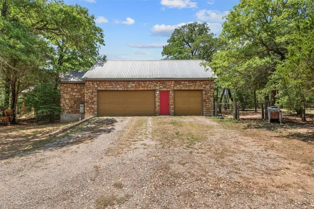 a view of a house with backyard and trees