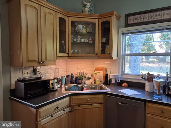 a kitchen with stainless steel appliances a sink window and cabinets