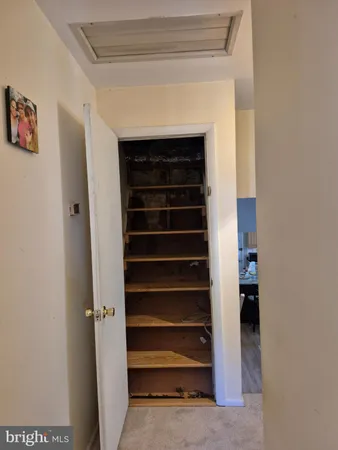 a view of closet with white walls and a window