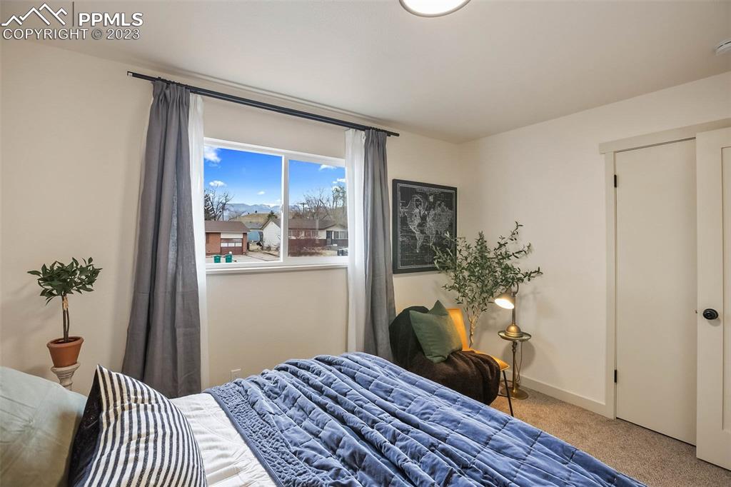 2415 Monterey Road Colorado Springs, CO 80910 - Photo 17 of 36 a bedroom with a bed table and a window