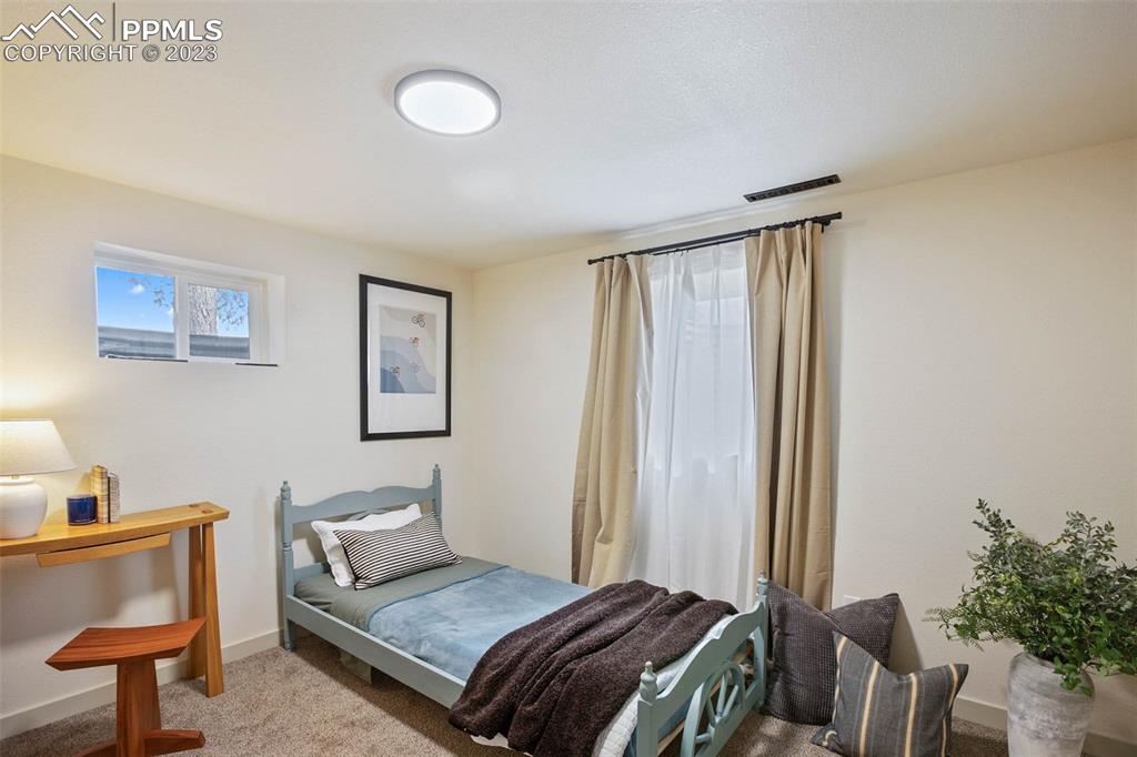 2415 Monterey Road Colorado Springs, CO 80910 - Photo 26 of 36 a bedroom with a bed and a lamp on dresser