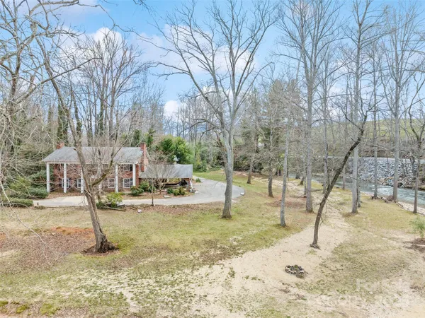 a view of a house with a yard and large tree