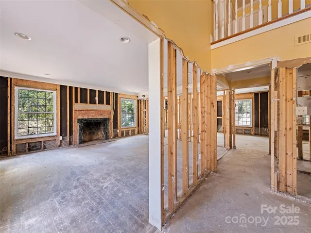 a view of an empty room with a fireplace and a window