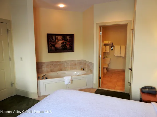 a bathroom with a tub sink and mirror