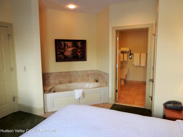 a bathroom with a tub sink and mirror