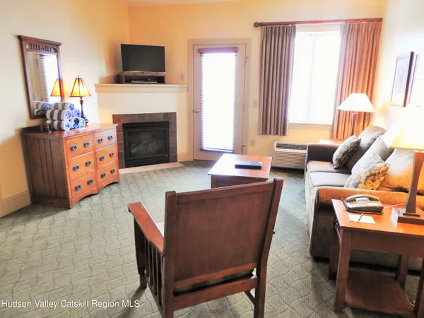 a living room with furniture a fireplace and a flat screen tv