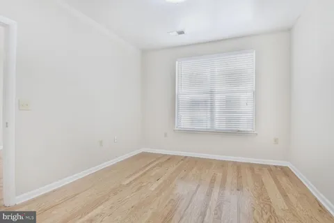 a view of a room with wooden floor and a window