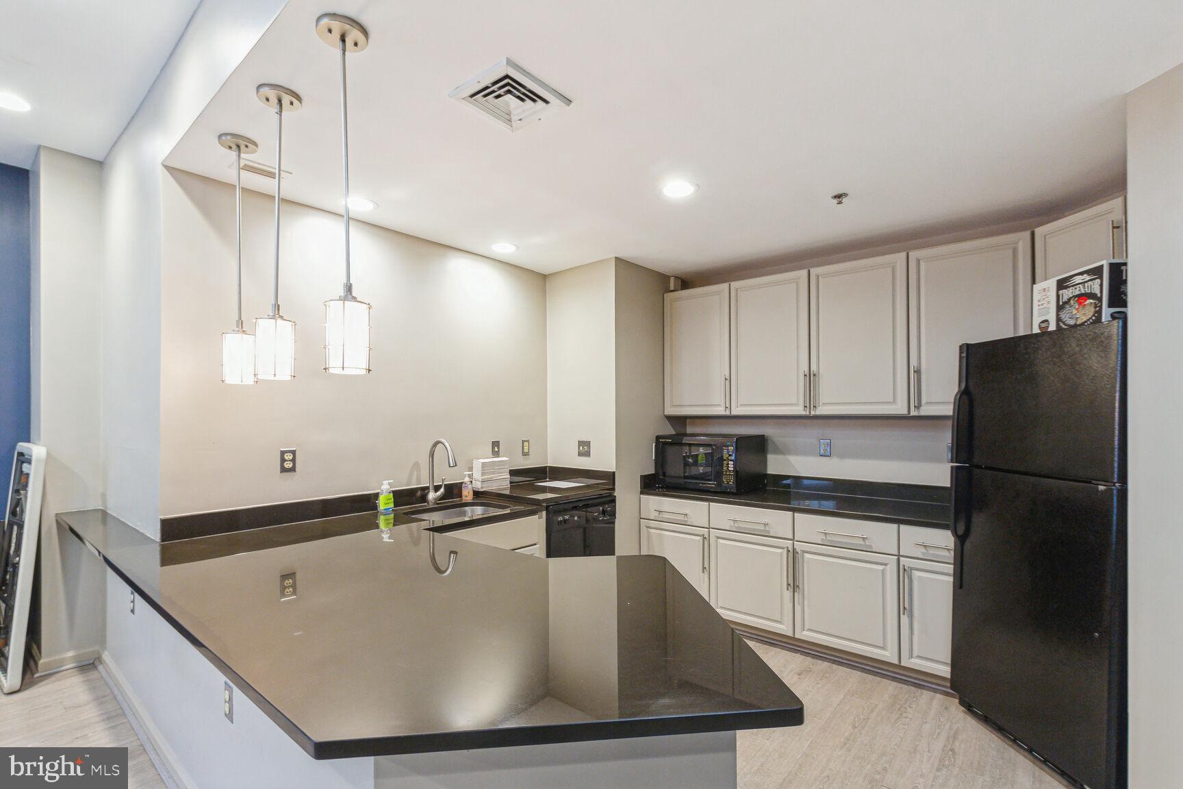 1201 East-West Highway, Unit 331 Silver Spring, MD 20910 - Photo 26 of 34 a kitchen with a sink a kitchen island and stainless steel appliances