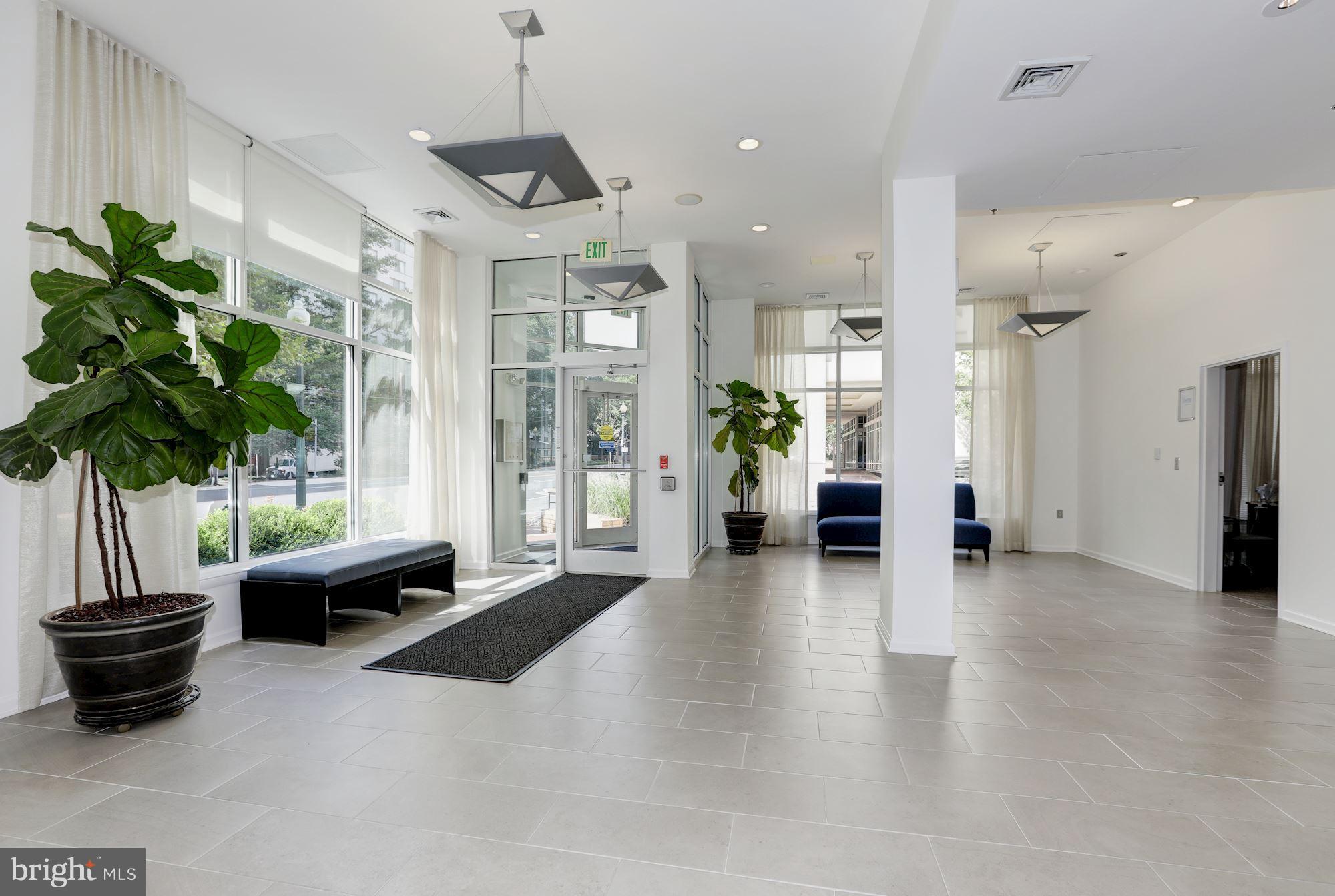 1201 East-West Highway, Unit 331 Silver Spring, MD 20910 - Photo 3 of 34 a living room with furniture potted plant and a chandelier