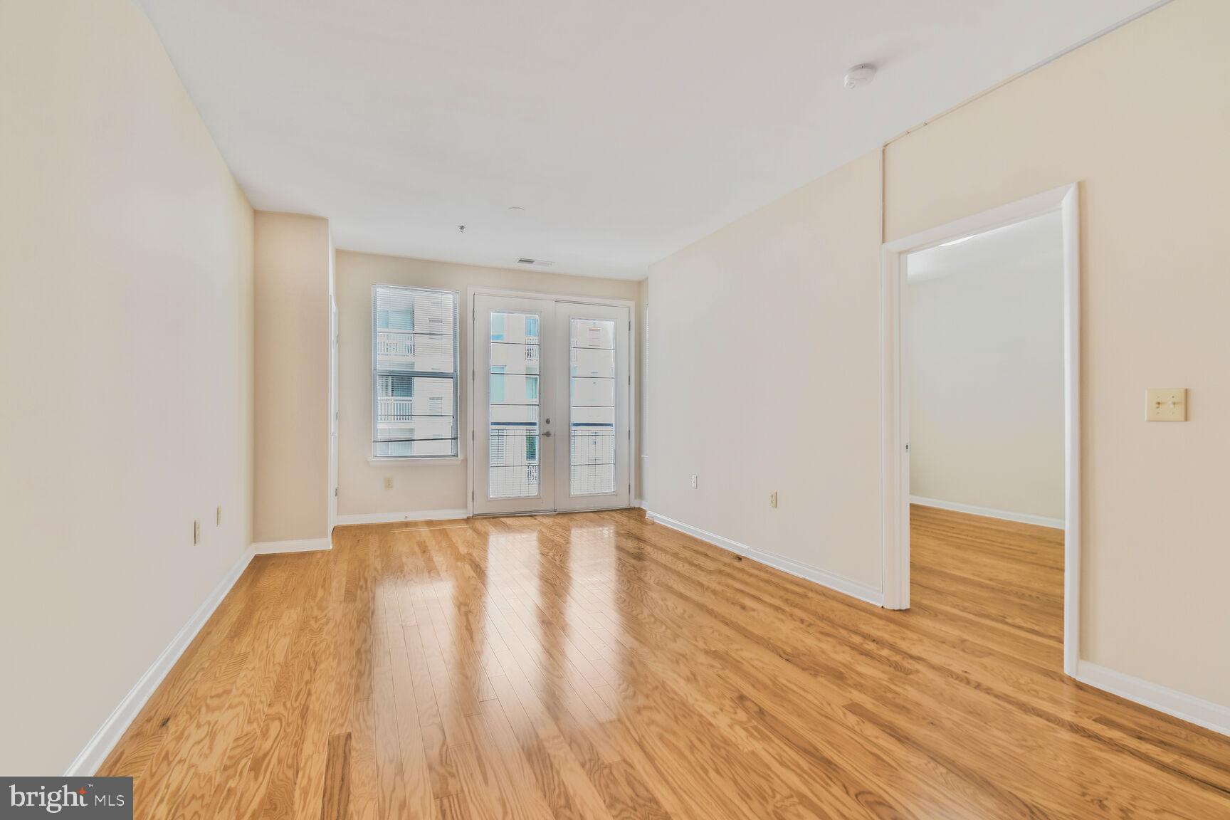 1201 East-West Highway, Unit 331 Silver Spring, MD 20910 - Photo 7 of 34 wooden floor in an empty room with a window