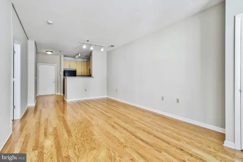 a view of empty room with wooden floor