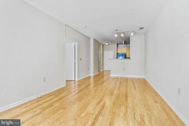 a view of a room with wooden floor and a ceiling fan