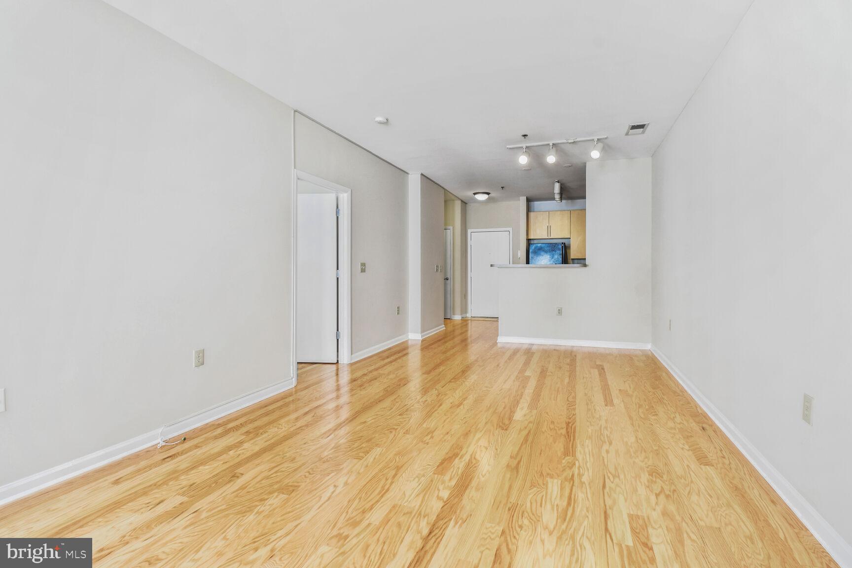 1201 East-West Highway, Unit 331 Silver Spring, MD 20910 - Photo 9 of 34 a view of a room with wooden floor and a ceiling fan