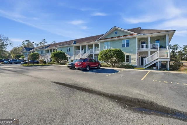 a front view of a house with a garden and parking