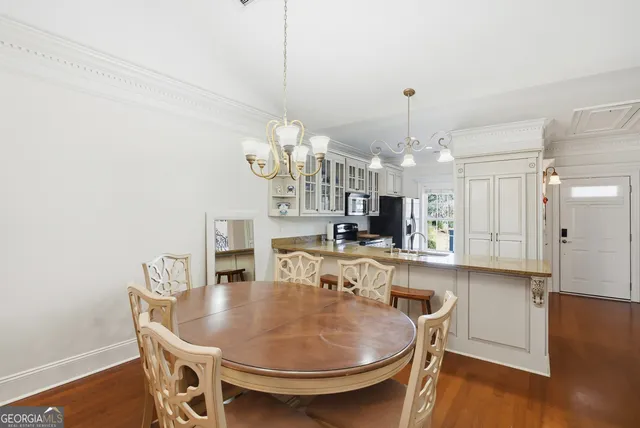 a kitchen with a table chairs refrigerator and cabinets