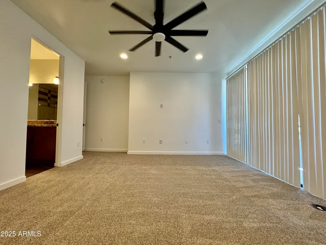 an empty room with fan and entrance