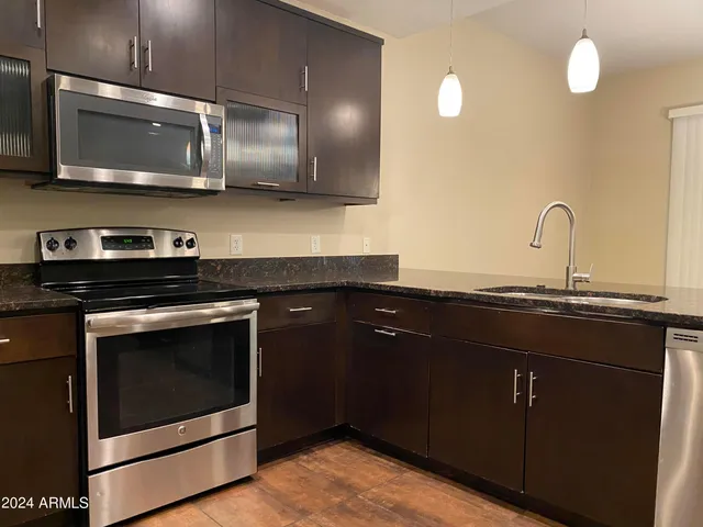a kitchen with stainless steel appliances granite countertop a stove and a microwave