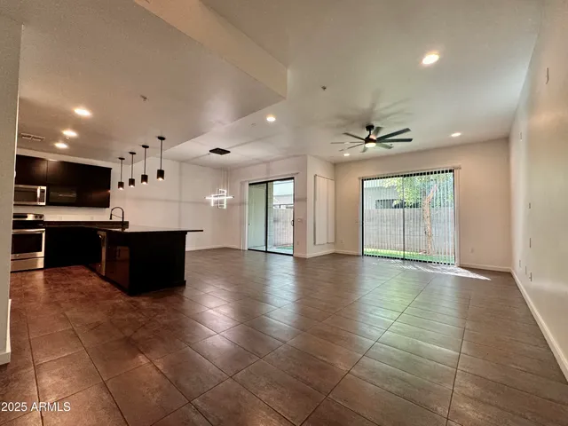 a large kitchen with stainless steel appliances a large counter top a stove and a refrigerator