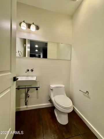 a bathroom with a toilet a sink and mirror