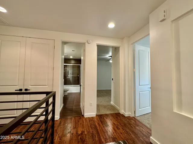 a view of a hallway with wooden floor and closet