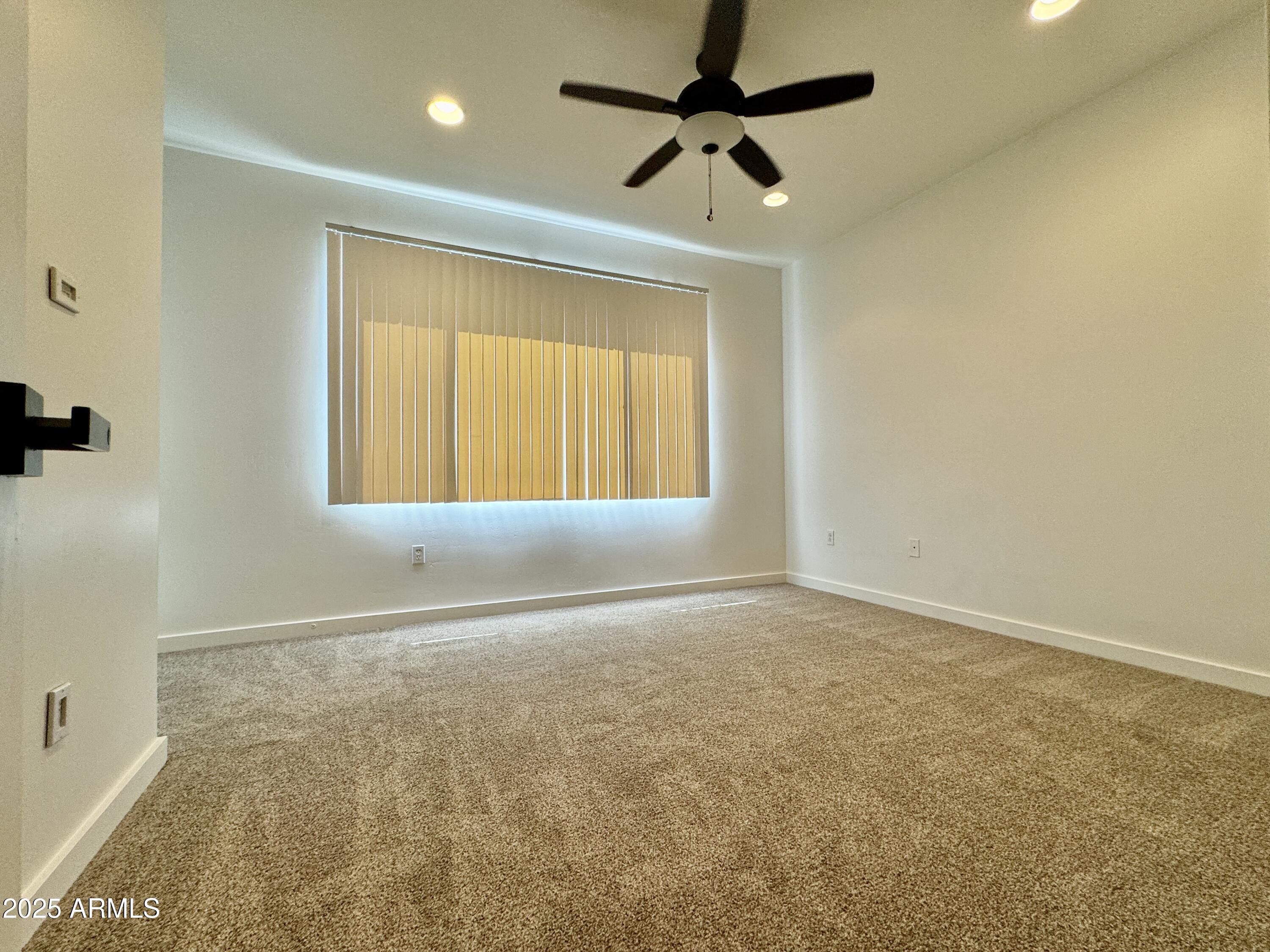 4230 North 21st Street, Unit 12 Phoenix, AZ 85016 - Photo 8 of 17 an empty room with a window and a ceiling fan