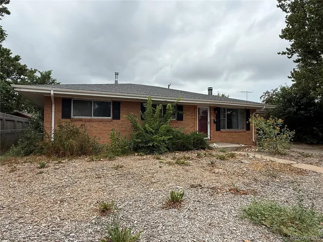 a front view of house with yard and trees around